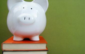 White ceramic piggy bank atop book