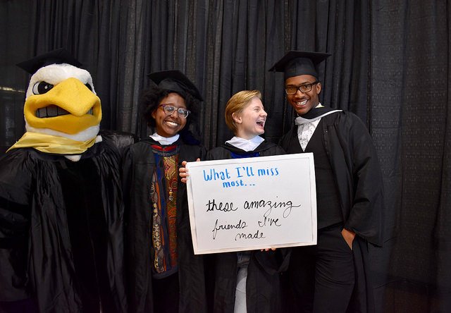 several graduating students pose for a photo that holds up a sign saying what they'll miss most about St. Mary's College of Maryland
