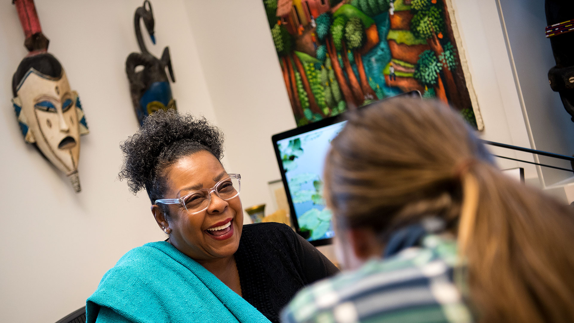 SMCM student and professor talking and laughing in the department office.