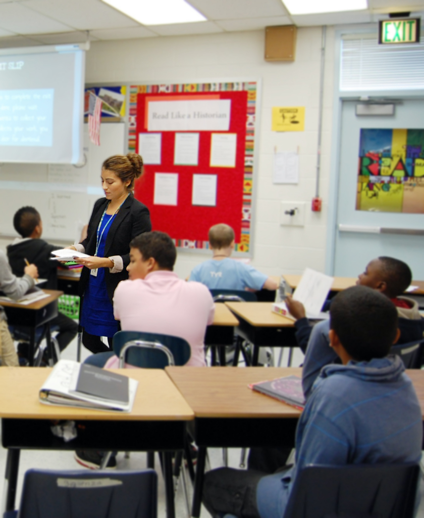 A student teacher walks through an elementary classroom.