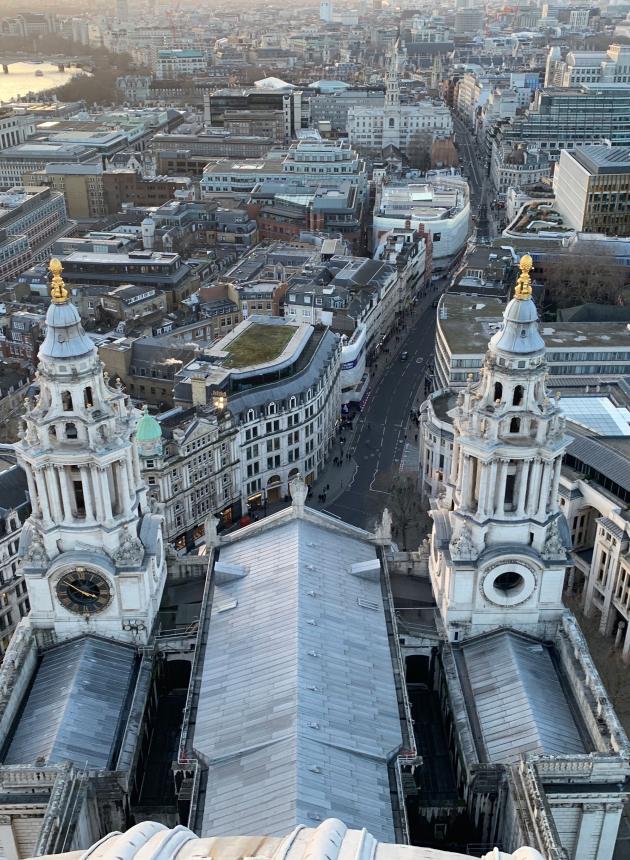 Aerial view of St. Paul’s Cathedral towers in London, with city streets and buildings sprawling into the distance.