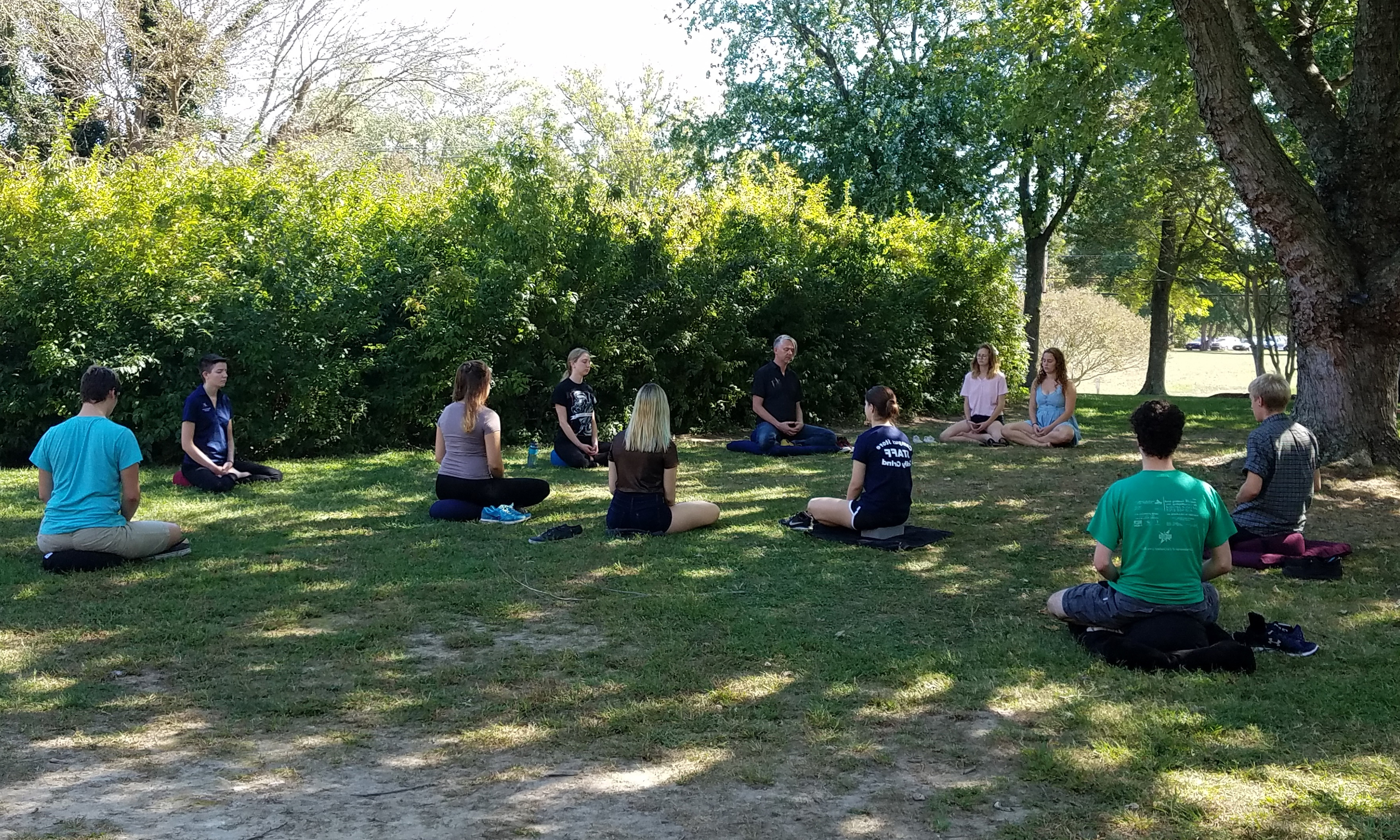 a class meditates outside