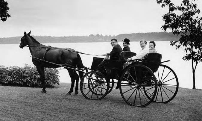 SMCM President May Russell's retirement in 1969 enjoying a horse drawn carriage ride along the St. Mary's River nearby the Alumni Lodge