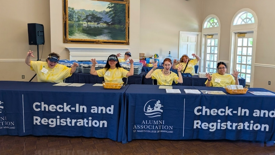 SMCM Students working the Check-in & Registration table at Alumni Weekend roar for the camera