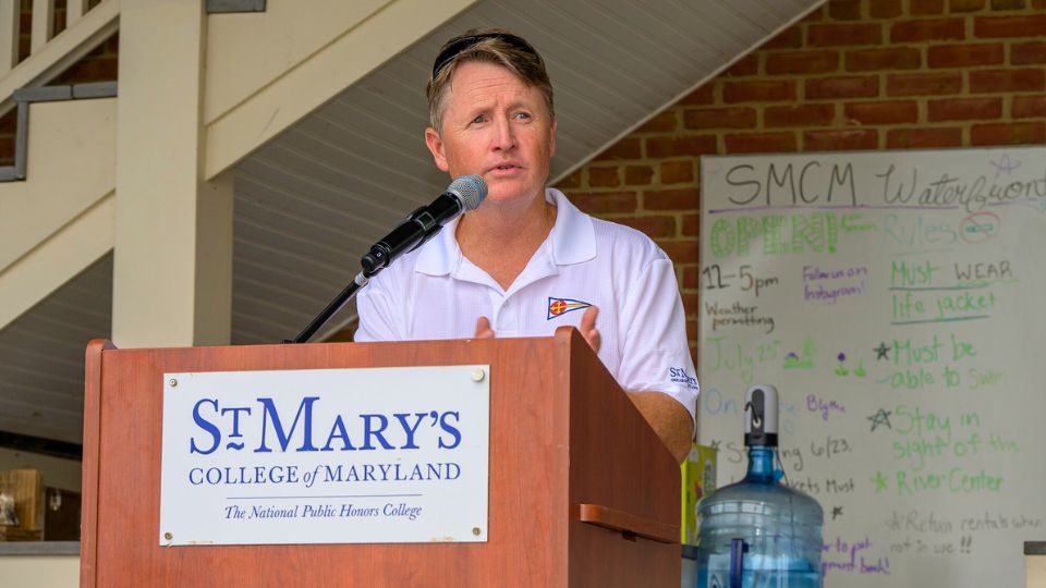 Director of Sailing Bill Ward speaks at a podium.