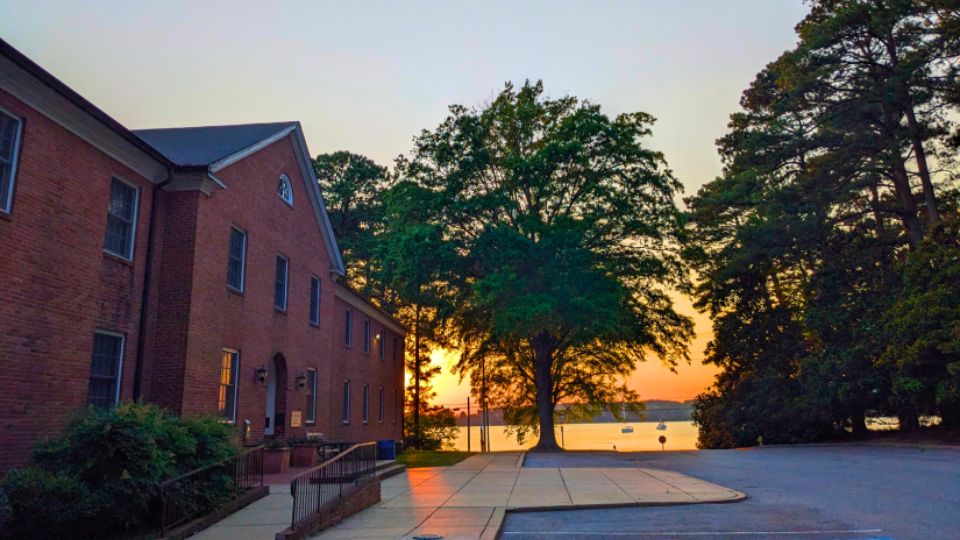 Queen Anne Hall dormitory at sunset with a view of the St. Mary's River.