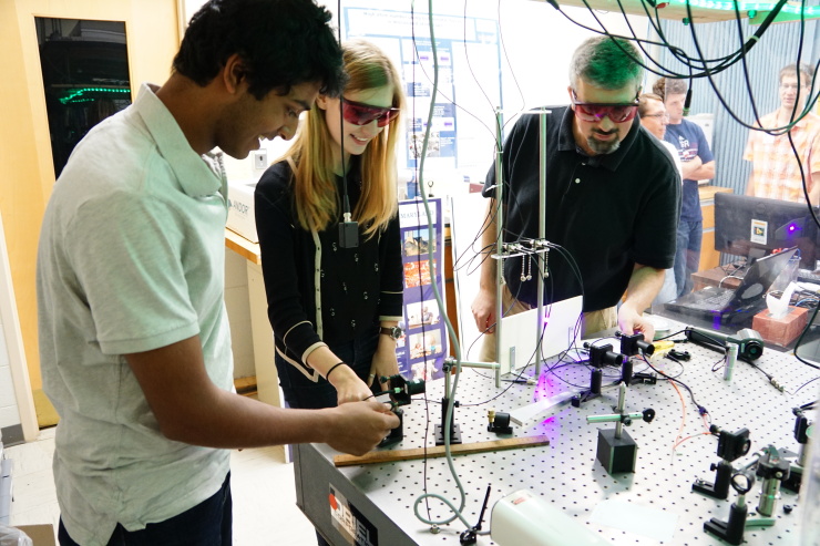 Students engaged in optics experiment