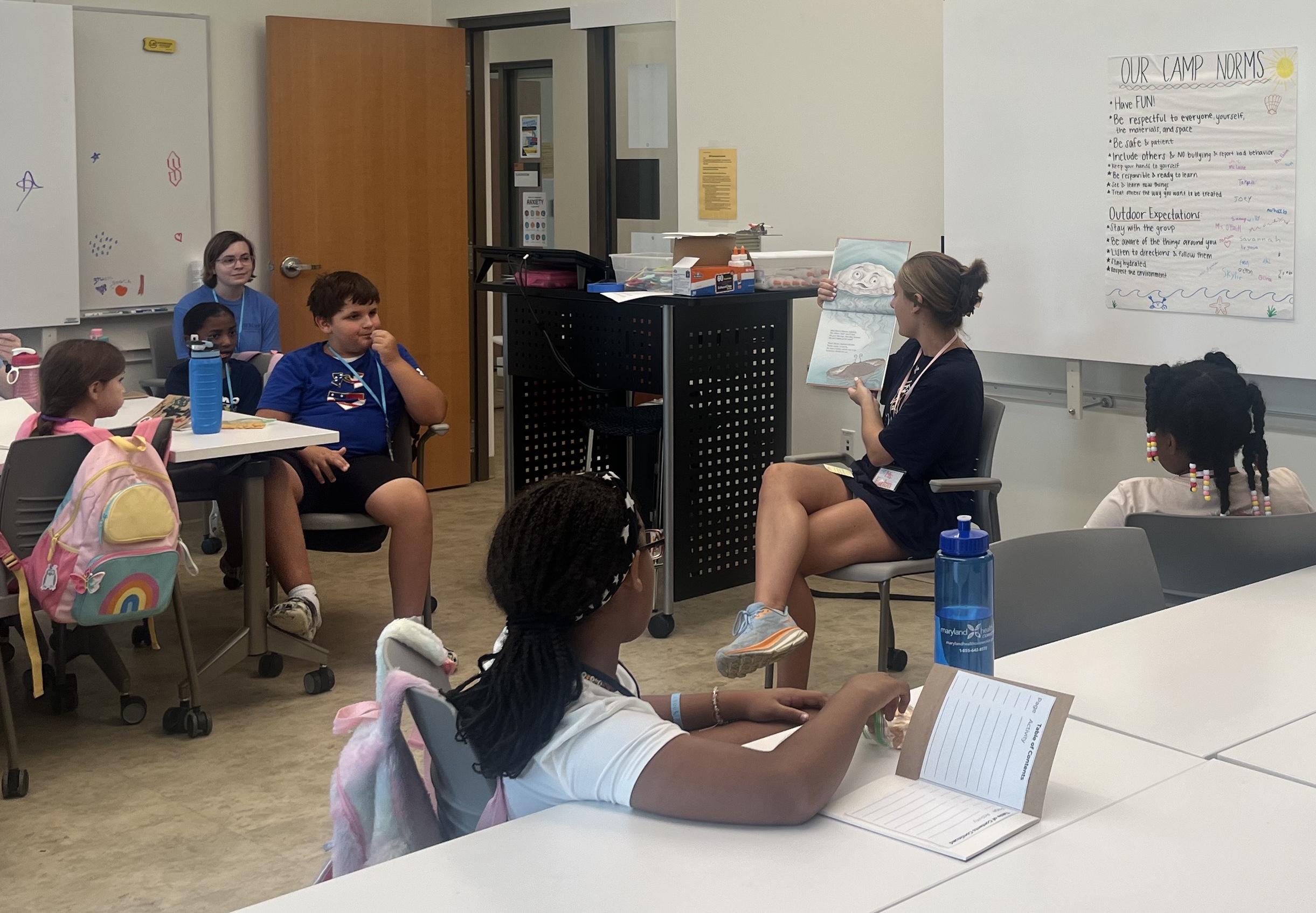 Educational Studies students read aloud to students in a classroom.