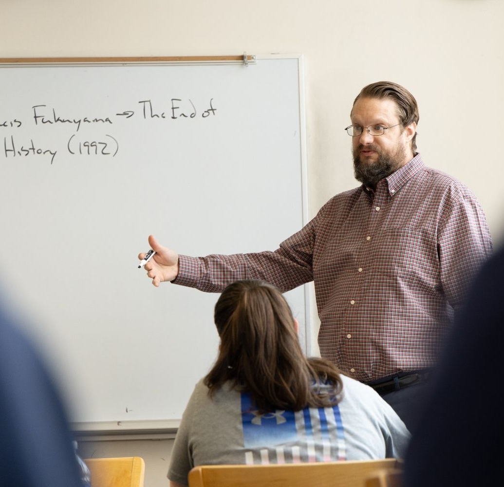 53819511421_38e942e193_o A man stands in front of a whiteboard giving a lecture to students. The whiteboard has the text “Francis Fukuyama → The End of History (1992)” written on it.