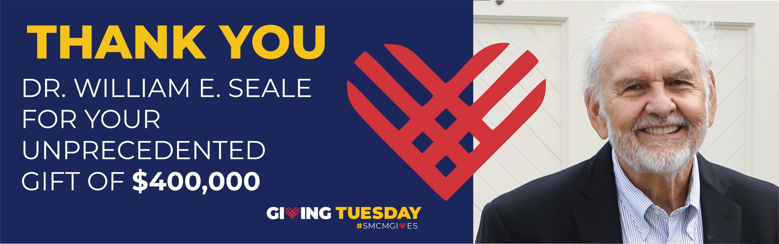 Dr. William E. Seale smiles next to a sign thanking him for a $400,000 Giving Tuesday donation, featuring a stylized red heart and bold text.