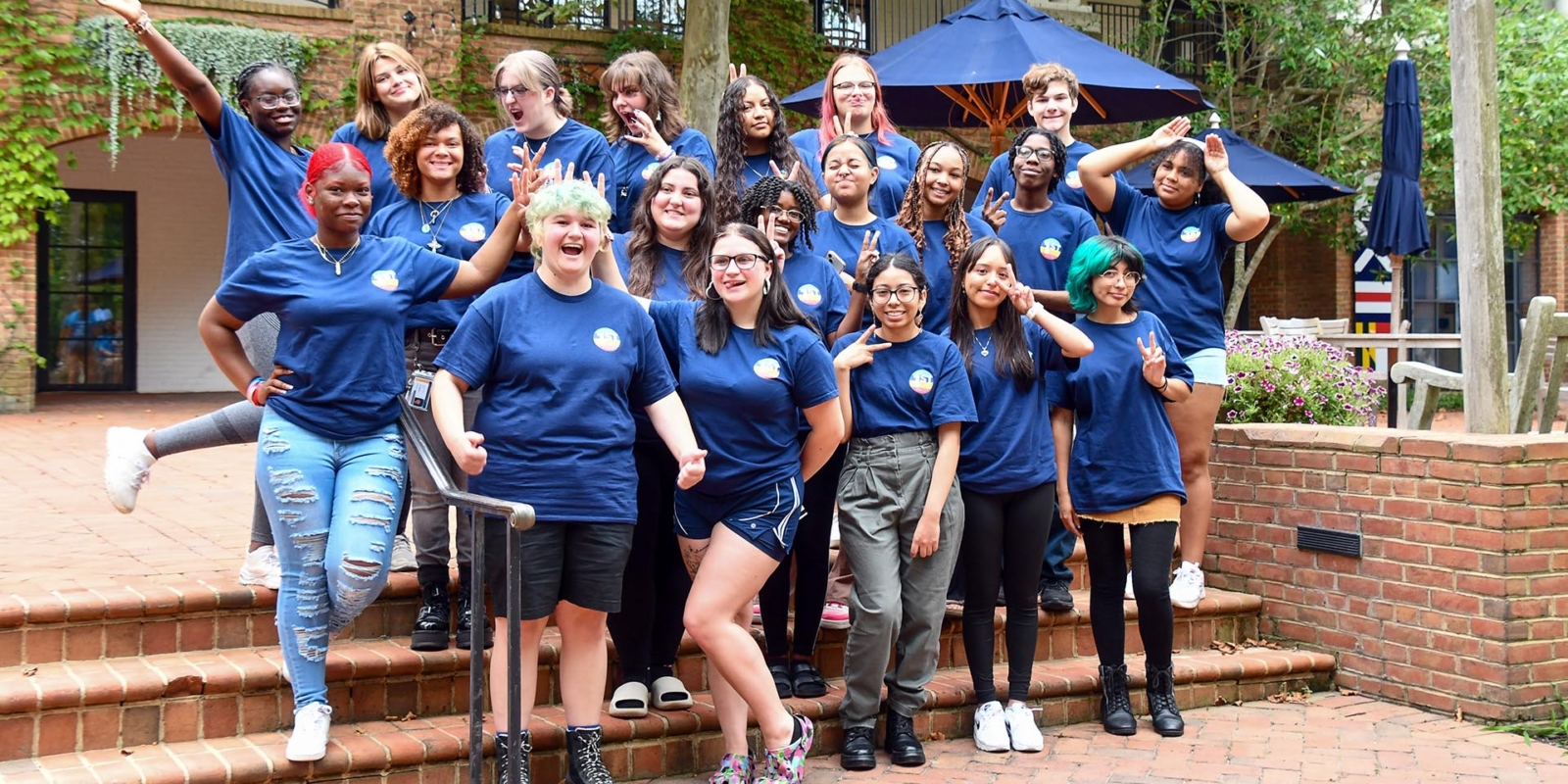 Image of students standing outside campus center wearing navy colored Sum Primus shirts