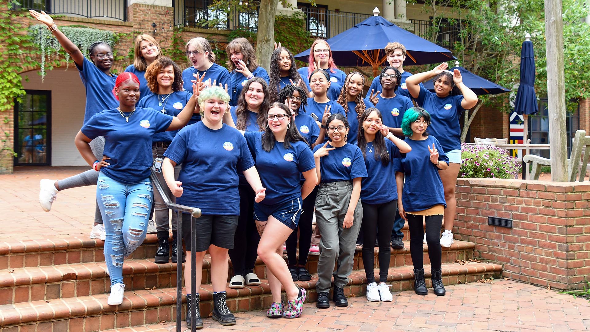 Image of students standing outside campus center wearing navy colored Sum Primus shirts
