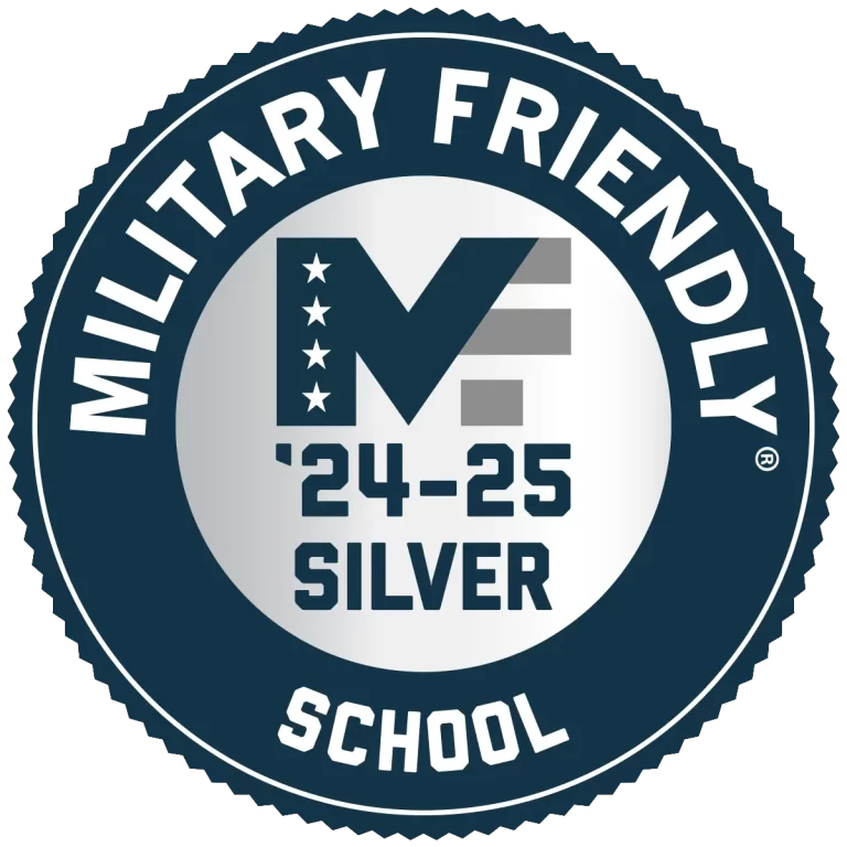 MSFS24-25_Silver_1200x1200-768×768 Circular badge with "Military Friendly School" on the border and "'24-'25 Silver" inside. A stylized "M" with stars and stripes is at the center.