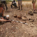 A student sits down in the field