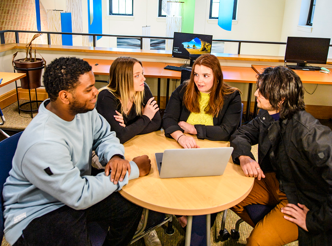 A group of St. Mary's College of Maryland students meeting around a table.