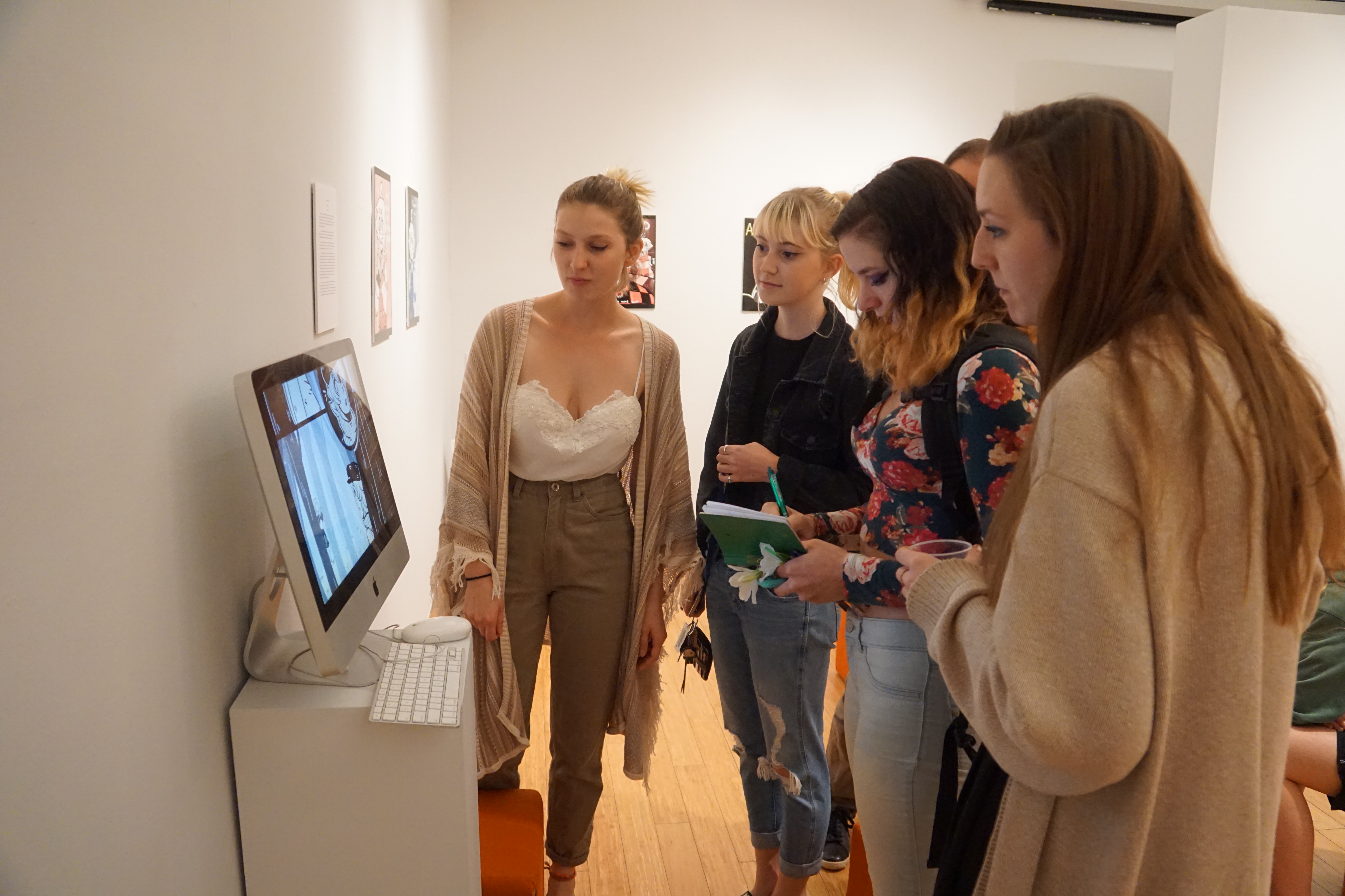 several smcm students examining art on a computer screen