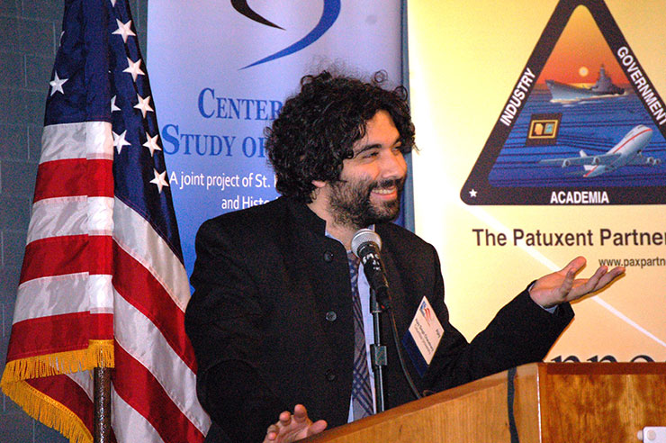 Dr. Ajay Singh Chaudhary lecturing from the podium at the Patuxent Defense Forum