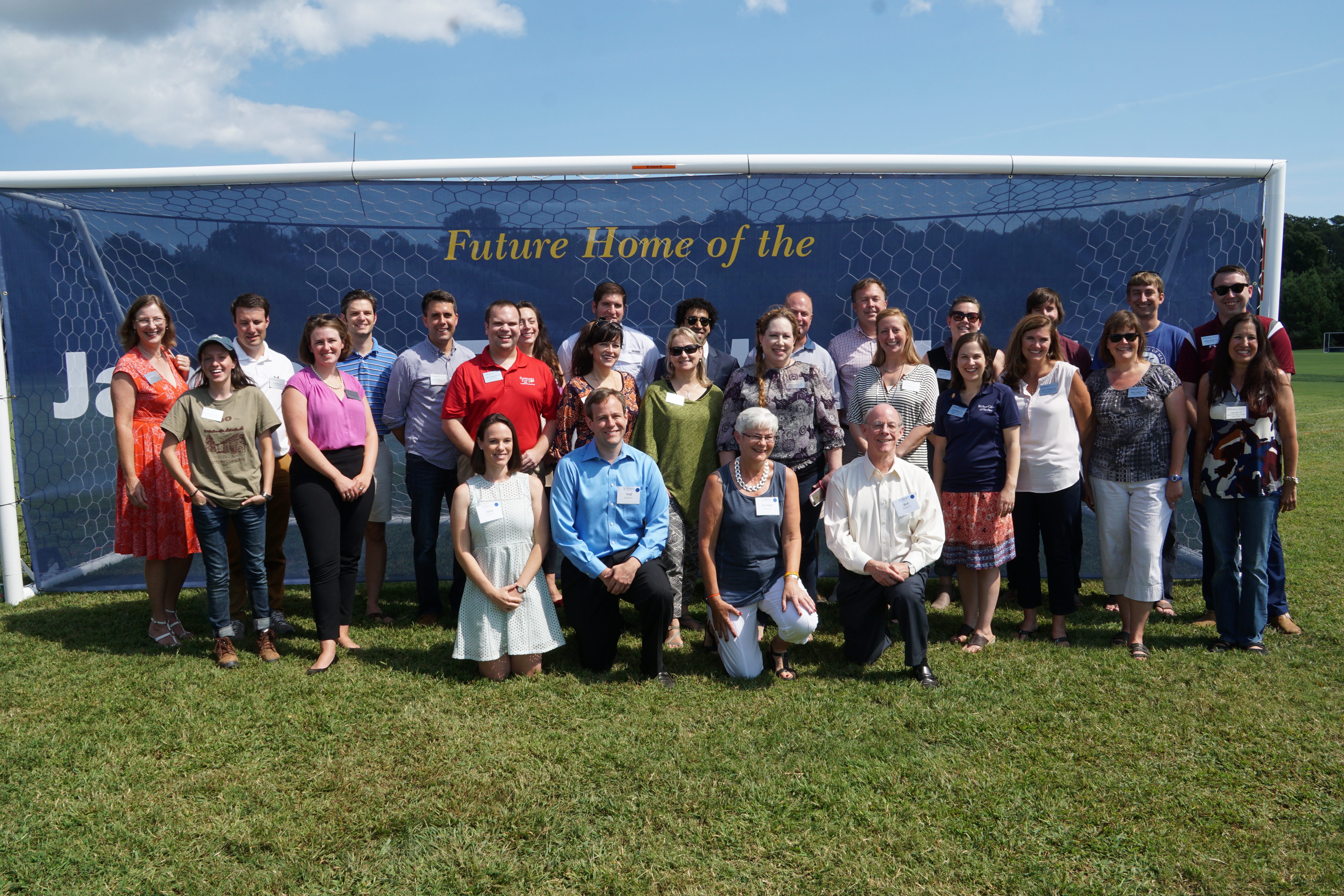The smcm team and donors pose in front of a soccer goal