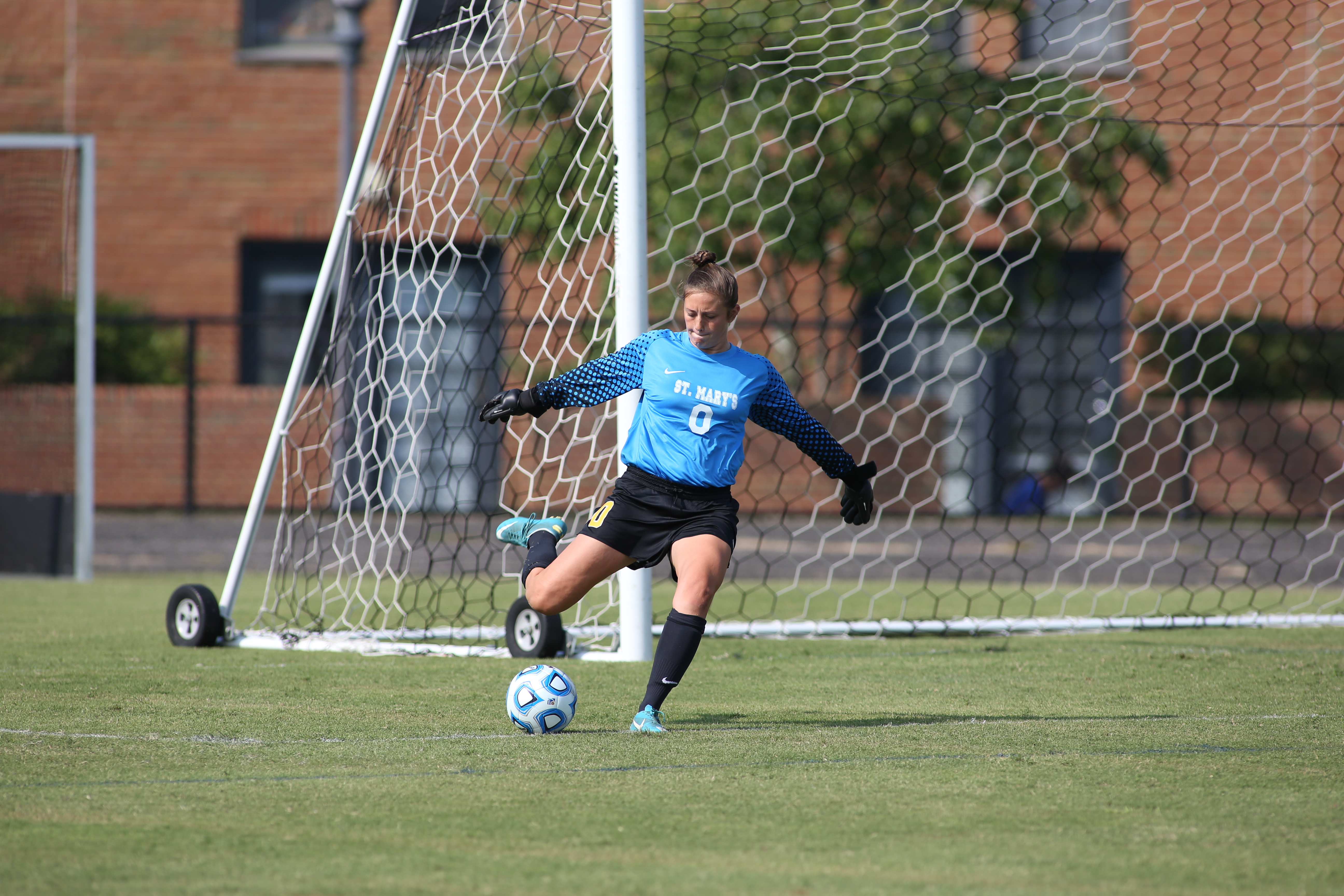 A SMCM Women's Soccer goalie kicking a ball