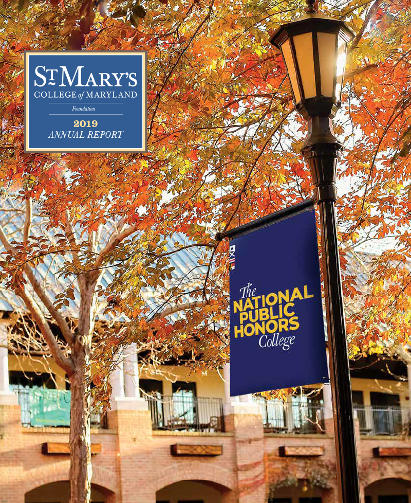 A lamppost with a "The National Public Honors College" banner stands amid autumn leaves. In the background is a brick building with arches and a tiled roof. The St. Mary's College of Maryland 2019 Annual Report cover is featured.