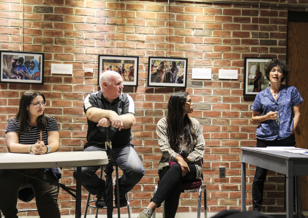 Several students and teachers sitting in a classroom in a discussion