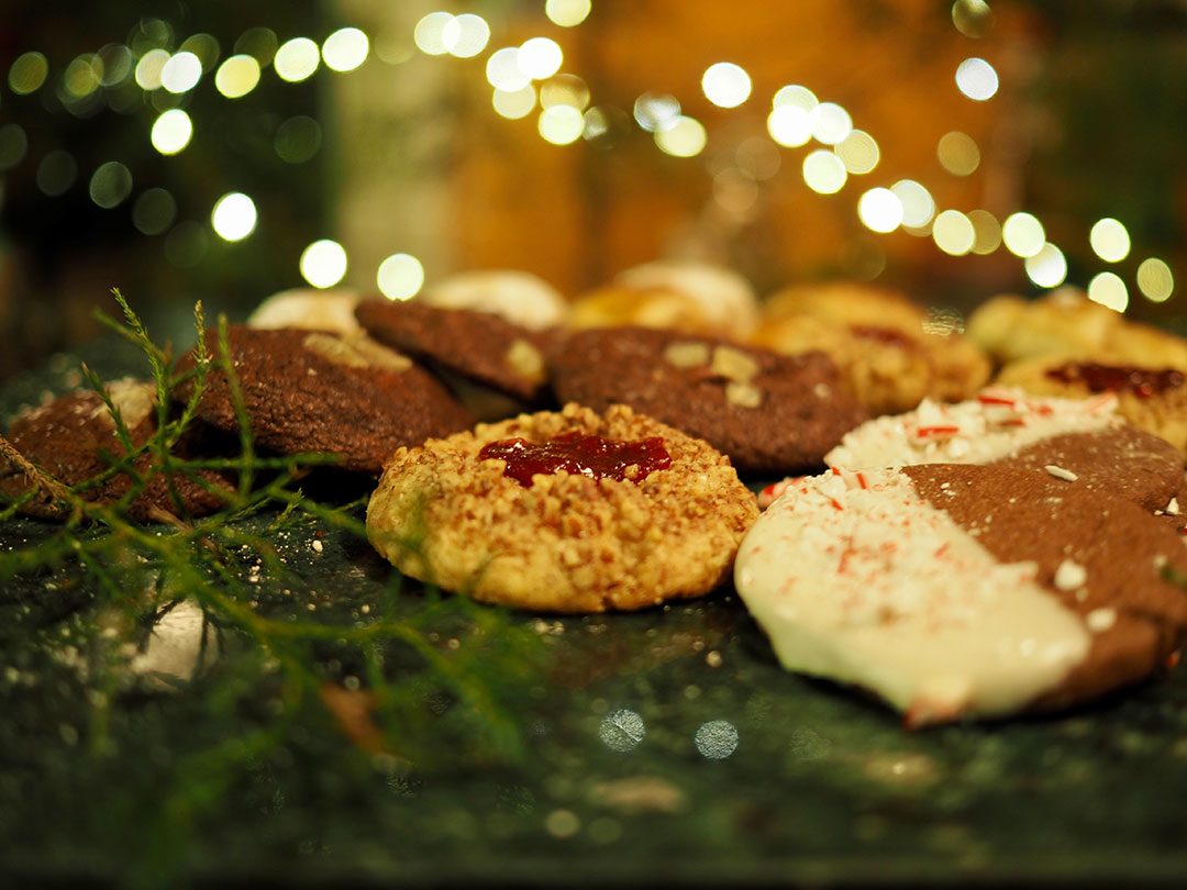 Maribeth Ganzell - Still life of holiday cookies on a platter of greenery with holiday lights background Maribeth Ganzell - Still life of holiday cookies on a platter of greenery with holiday lights background