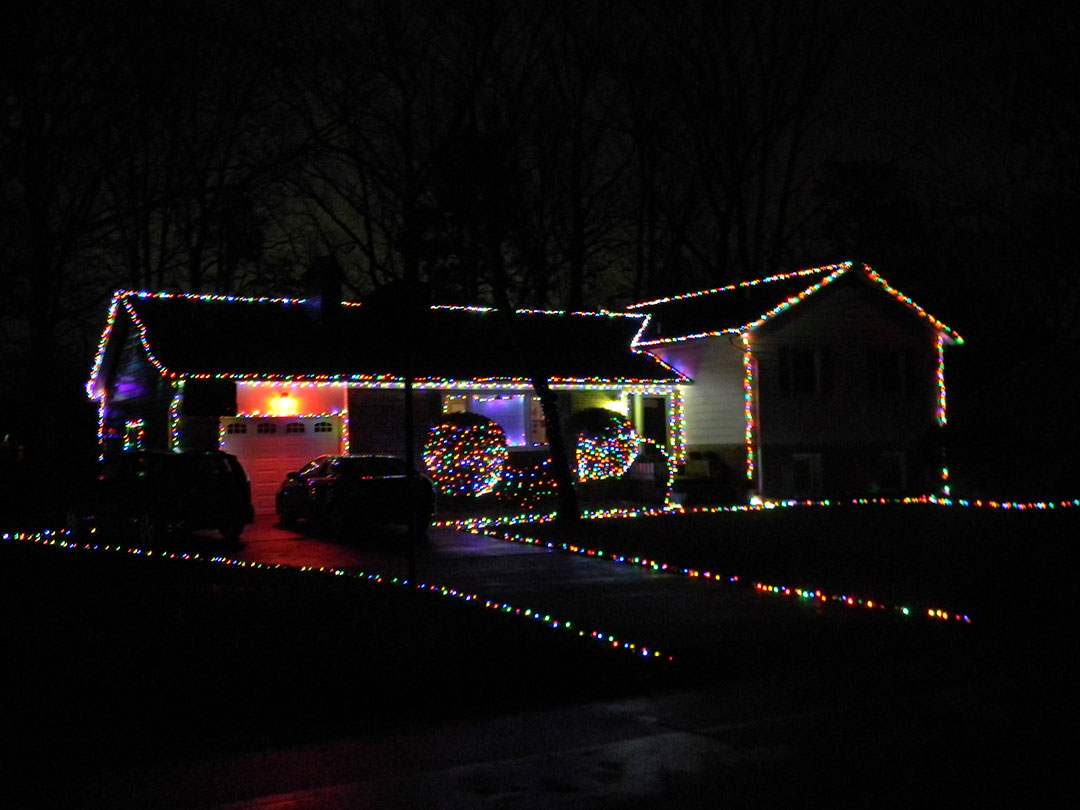 Aaron Koch - House decorated with colorful lights outlining the edges, hedges, and driveway Aaron Koch - House decorated with colorful lights outlining the edges, hedges, and driveway